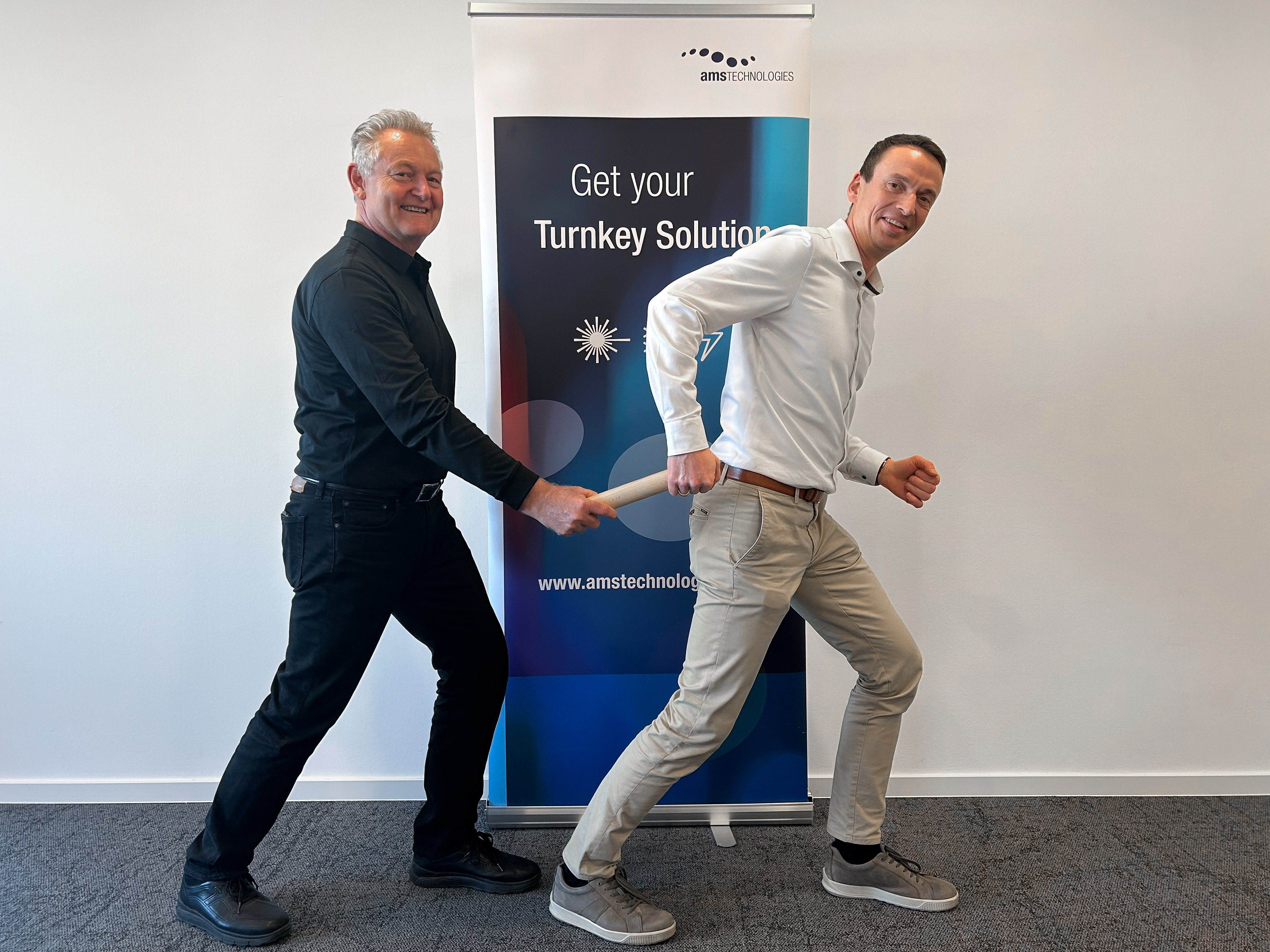 Photo of Michael Lee and Klaus Maier handing over a symbolic baton